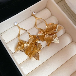 Macro detail of gold leaf fringe earrings with zircons in a white velvet jewelry box
