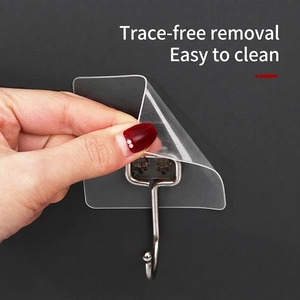Heavy duty transparent adhesive wall hook with stainless steel J-hook shown being peeled