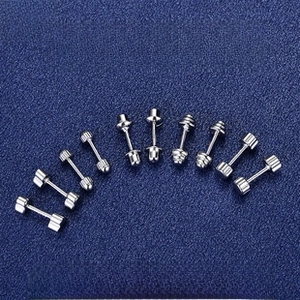 Macro view of five pairs of silver screw-back stud earrings in various geometric shapes