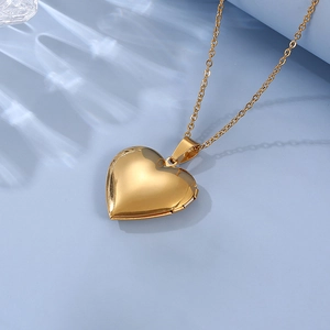 Close-up of golden heart locket necklace on blue background with water light effects