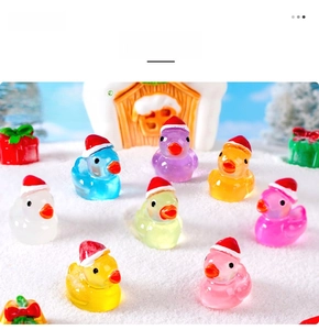 Close-up of translucent colorful resin ducks with mini red Christmas hats for decor