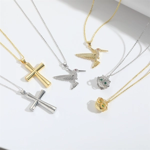 Retro cross and bird pendant necklaces in gold and silver finish on white background
