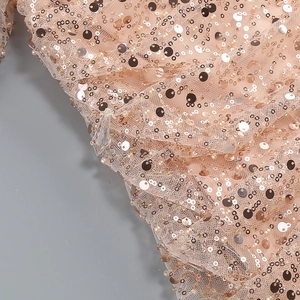 Detail of pink sequin fabric with fine beadwork and mesh texture on the dress