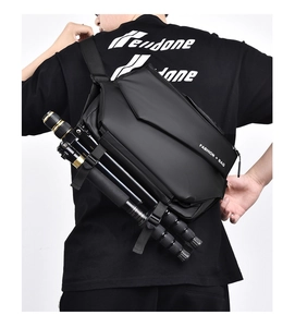 Close-up of a black crossbody tactical bag featuring a tripod attachment and logo