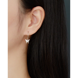 Macro shot of S925 sterling silver butterfly drop earring with pavé diamonds on model ear