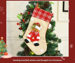 Detail of Christmas stocking with reindeer character and snowflakes hanging on a tree