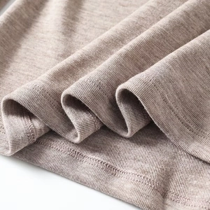 Detail von hellbraunem Strickstoff mit weicher Textur und hochwertiger Doppelnaht