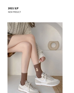 Détail de chaussettes en coton côtelé marron avec broderie ours doré champagne sur le côté