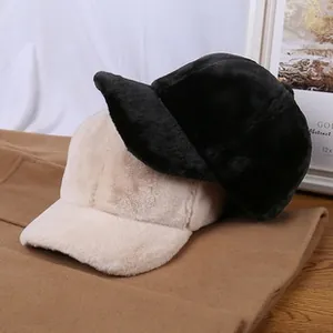 Detail view of fuzzy teddy fleece baseball caps in black and beige with soft faux fur texture