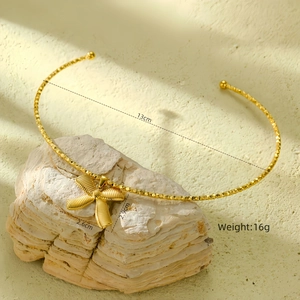 Detailed view of golden stainless steel bow necklace with 13cm diameter and 16g weight
