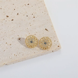 Macro shot of gold sunburst evil eye stud earrings with zircon inlay on stone