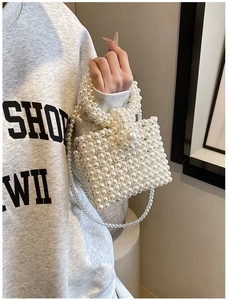 Close-up of elegant pearl beaded handbag with woven texture and decorative bead buckle