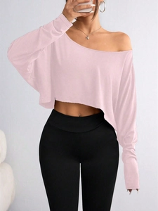 Close-up of pink off-shoulder cropped long sleeve top with slim fit design