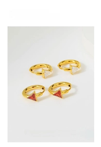 Detailed shot of gold hoop earrings with red and white triangle zircon pendants