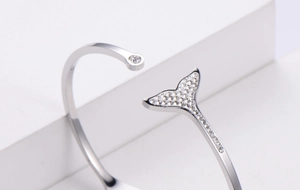 Macro shot of dolphin tail bracelet with sparkling cubic zirconia on white steps