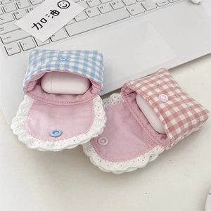 Close-up of quilted lace headphone cases in blue and pink on a laptop keyboard