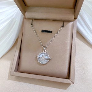 Detailed close-up of shell planet pendant with zircon crystals on a silver chain