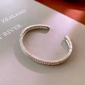 Silver-tone open C-shaped cuff bracelet with micro-paved zircons and engraved details
