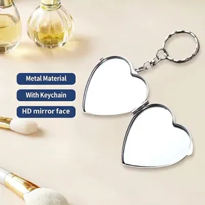 Foldable heart-shaped silver makeup mirror keychain on a cream aesthetic background