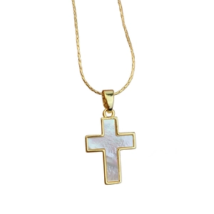 Classic gold cross necklace with white mother of pearl inlay on white background