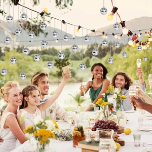 Hanging silver mini disco mirror balls decorating an outdoor party and wedding celebration