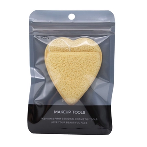 Macro detail of heart-shaped yellow cleansing sponge with lanyard in clear packaging