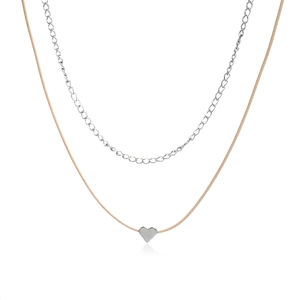 Detail of a minimalist double-layer necklace with a silver heart pendant on a beige cord