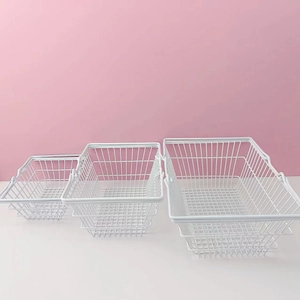 Three-piece set of white metal mesh storage baskets in different sizes with handles