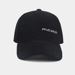 Detail of white mama embroidery on black corduroy baseball cap with striped texture
