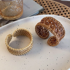 Detailed view of handmade woven rattan open bracelets in natural and dark brown textures