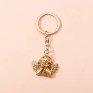 Detailed close-up of a vintage gold cupid angel keychain with feathered wings detail