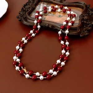 Double-layered vintage necklace with deep red beads and white pearls on leather