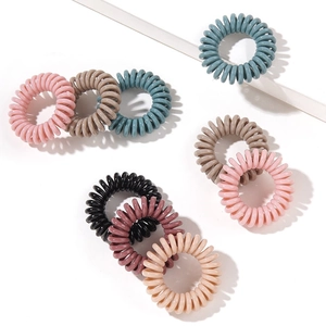 Elastic spiral hair ties set in pink, blue, brown, black, and beige on white background