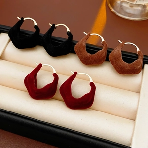 Close-up of velvet flocking irregular hoop earrings in black, brown, and wine red colors