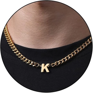 Close-up of golden Cuban link chain featuring a capital letter K pendant on a model