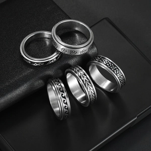 Five styles of rotating stainless steel anxiety rings with floral and wave engravings