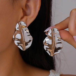 Textured silver leaf earrings with metallic ripple finish shown on model's ear