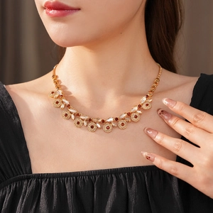 Detail of vintage gold necklace featuring amber and clear zircons on female model