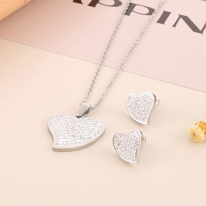 Close-up of a silver heart jewelry set featuring sparkling rhinestones on necklace and studs