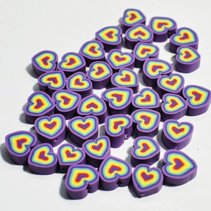 Perline colorate a forma di cuore in argilla polimerica per gioielli fai da te su sfondo bianco