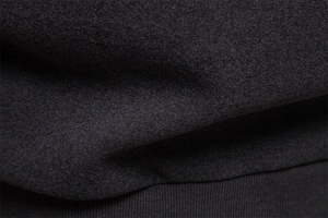 Detailed macro view of black hoodie fabric texture and ribbed hem for warm winter wear