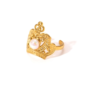 Detailed view of a gold-tone crown ring featuring a central white pearl on a white background