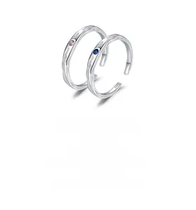 Macro detail of S925 sterling silver ring with water ripple texture and pink and blue gems