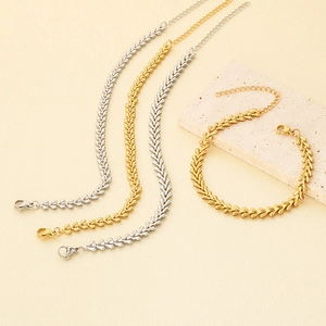 Detailed close-up of gold and silver heart-shaped chain bracelets with lobster clasps