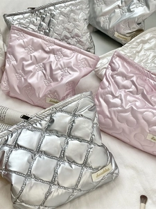 Quilted heart pattern silver and pink PU leather multi-purpose makeup bags on white fabric