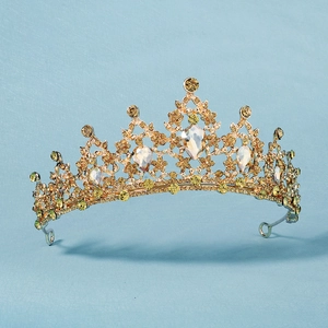 Luxurious gold crown with yellow and clear rhinestones on a blue gradient background