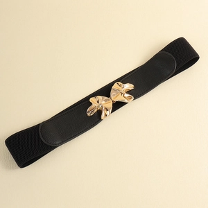 Detail of black elastic waist belt featuring a gold floral metal buckle on beige background