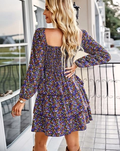 Détail d'une robe fleurie violette à volants avec un col carré et des manches longues
