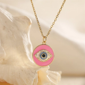 Close-up of pink enamel evil eye pendant with blue and clear zircon on a gold chain