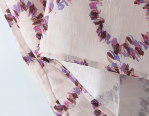 Close-up of floral chiffon fabric showing detailed stitching and semi-sheer texture
